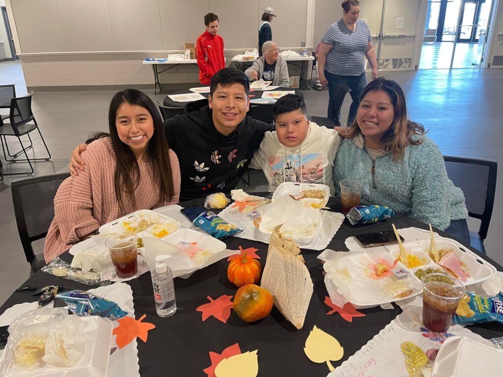 Four people enjoying a meal at the 2021 Community Thanksgiving event